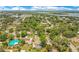 This aerial shows a neighborhood setting with lush trees and a glimpse of a distant lake at 1531 Huntington St, Lakeland, FL 33801