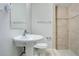 Cozy bathroom featuring a pedestal sink, toilet, and tiled shower at 1531 Huntington St, Lakeland, FL 33801