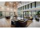 Amenity center lounge with tall ceilings, ceiling fans, large windows, modern furniture, and community table at 15975 Marina Bay Dr, Winter Garden, FL 34787