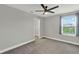 Bedroom features neutral walls, carpet, white trim, and a bright window with blue curtains at 15975 Marina Bay Dr, Winter Garden, FL 34787