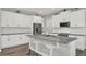 Modern kitchen with stainless steel appliances, granite countertops, a central island, and white cabinets at 15975 Marina Bay Dr, Winter Garden, FL 34787