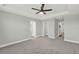 Large main bedroom with neutral walls, carpet, ceiling fan, tray ceiling, and white trim at 15975 Marina Bay Dr, Winter Garden, FL 34787