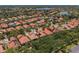 An aerial view of a neighborhood showcasing houses with terracotta roofs surrounded by lush greenery and a lake at 1638 Whitney Isles Dr, Windermere, FL 34786