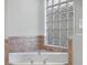 A close up of the bathtub featuring decorative tile and a glass block window for natural light at 1638 Whitney Isles Dr, Windermere, FL 34786