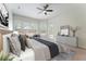 The staged main bedroom features neutral decor, a ceiling fan, a sitting area, and three large windows at 1638 Whitney Isles Dr, Windermere, FL 34786