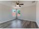 This well lit bedroom has wood floors, a ceiling fan, and a large window at 1638 Whitney Isles Dr, Windermere, FL 34786