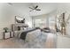The staged main bedroom features neutral decor, a ceiling fan, a sitting area, and three large windows at 1638 Whitney Isles Dr, Windermere, FL 34786