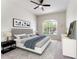 A staged bedroom with a ceiling fan and a window overlooking a tree lined street and homes across the street at 1638 Whitney Isles Dr, Windermere, FL 34786