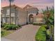 Elegant home featuring a barrel tile roof, manicured landscaping, and a paver driveway at 1638 Whitney Isles Dr, Windermere, FL 34786