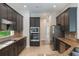 Updated kitchen featuring dark wood cabinets, granite countertops, and stainless steel appliances at 1638 Whitney Isles Dr, Windermere, FL 34786