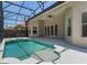 An in-ground pool is surrounded by a patio and the home's exterior, featuring double doors and a ceiling fan at 1638 Whitney Isles Dr, Windermere, FL 34786