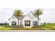 Beautiful clubhouse with a modern farmhouse design, manicured landscaping and mature palm trees at 1664 Crowncrest Dr, Apopka, FL 32703