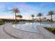 A resort-style community pool surrounded by palm trees, lounge chairs, and lush landscaping at 1664 Crowncrest Dr, Apopka, FL 32703