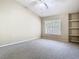 Neutral bedroom featuring carpet, a ceiling fan, a window, and built-in shelves at 1810 Shadow View Cir # 1810, Maitland, FL 32751