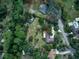 An aerial view of a home surrounded by lush trees and expansive lawns at 205 Elaine Pl, Chuluota, FL 32766