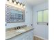 Bathroom vanity featuring granite countertop, decorative mirror and vanity lighting at 205 Elaine Pl, Chuluota, FL 32766