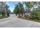 Home with a brick-trimmed garage and freshly poured concrete driveway, framed by mature trees and green landscaping at 205 Elaine Pl, Chuluota, FL 32766
