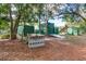 Various green outbuildings, including sheds and a trailer, surrounded by trees and pine needle ground cover at 205 Elaine Pl, Chuluota, FL 32766
