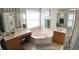 Primary bath with a large corner soaking tub, double sinks, and a separate glass enclosed shower at 2343 Walnut Heights Rd, Apopka, FL 32703