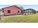 A large backyard with lush grass, the exterior of the house, and a screened-in pool at 2409 Pinyon Ct, Kissimmee, FL 34746