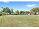 A very large grassy backyard with a view of the back of the house and screened in pool at 2409 Pinyon Ct, Kissimmee, FL 34746