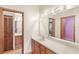 Bathroom with dual sinks, wood cabinets, and a large mirror reflecting the adjacent rooms at 2409 Pinyon Ct, Kissimmee, FL 34746