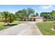 Charming single-story home featuring a 2-car garage, lush lawn, and mature trees at 2409 Pinyon Ct, Kissimmee, FL 34746