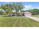 Charming single-story home with mature trees and a lush green lawn at 2409 Pinyon Ct, Kissimmee, FL 34746