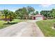 Charming single-story home with a spacious driveway, attached garage, lush lawn, and mature landscaping at 2409 Pinyon Ct, Kissimmee, FL 34746