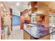 Kitchen featuring wood cabinetry, tile floors, and a bar overlooking the living area at 2409 Pinyon Ct, Kissimmee, FL 34746
