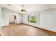 Spacious living room with ceiling fan, a large window, and light wood-look flooring at 2409 Pinyon Ct, Kissimmee, FL 34746
