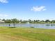 Picturesque pond view with a fountain, surrounded by green grass and mature trees at 2409 Pinyon Ct, Kissimmee, FL 34746