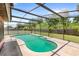 Screened-in pool surrounded by lush greenery and a well-maintained backyard at 2409 Pinyon Ct, Kissimmee, FL 34746