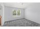 A serene bedroom with neutral tones, carpet flooring, and a window offering natural light at 2430 Little Gem Loop, Sanford, FL 32773