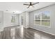 Inviting living room featuring wood-look flooring, large windows, and a sliding glass door for access to the outside at 2430 Little Gem Loop, Sanford, FL 32773