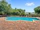 Community pool surrounded by brick pavers, lounge chairs, and lush landscaping for relaxation at 2430 Little Gem Loop, Sanford, FL 32773