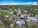 Aerial view of a home with a screened pool and solar panels in a community surrounded by lush trees at 2550 Meadowview Ln, Deland, FL 32720