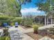 Landscaped backyard with a paved patio, patio furniture, potted plants, and a screened-in enclosure at 2550 Meadowview Ln, Deland, FL 32720