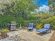 An outdoor patio with a grill, a decorative tree, and blue lounge chairs ready for relaxing at 2550 Meadowview Ln, Deland, FL 32720