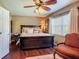This cozy bedroom is warmly lit and features hardwood floors, ceiling fan, and a large window at 2550 Meadowview Ln, Deland, FL 32720
