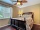 Well-lit bedroom features dark wood floors, a window, and ceiling fan at 2550 Meadowview Ln, Deland, FL 32720