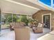 This covered lanai includes wicker furniture and views of the pool and back yard at 2550 Meadowview Ln, Deland, FL 32720