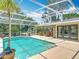 View of the beautiful screened in pool and back yard, as seen from behind the palm tree at 2550 Meadowview Ln, Deland, FL 32720