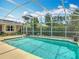 Aerial view of the pool, pool deck, screened enclosure, lush landscaping, and the back of the house at 2550 Meadowview Ln, Deland, FL 32720