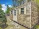 A well-kept utility shed with windows and a door surrounded by greenery and a blue sky backdrop at 2550 Meadowview Ln, Deland, FL 32720