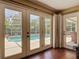 This sun room has hardwood floors and three sets of doors which allow for views of the back yard and pool at 2550 Meadowview Ln, Deland, FL 32720