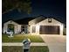 Charming single-Gathering home with a well-manicured lawn and a two-car garage, illuminated at night at 2620 Abbey Ave, Orlando, FL 32833