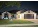 Charming single-Gathering home with a well-manicured lawn and a two-car garage, illuminated at night at 2620 Abbey Ave, Orlando, FL 32833