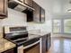 Kitchen featuring stainless steel oven with sleek dark cabinets and granite countertops at 2620 Abbey Ave, Orlando, FL 32833