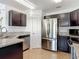 Well-lit kitchen featuring stainless steel appliances, granite countertops, and dark wood cabinets at 2620 Abbey Ave, Orlando, FL 32833